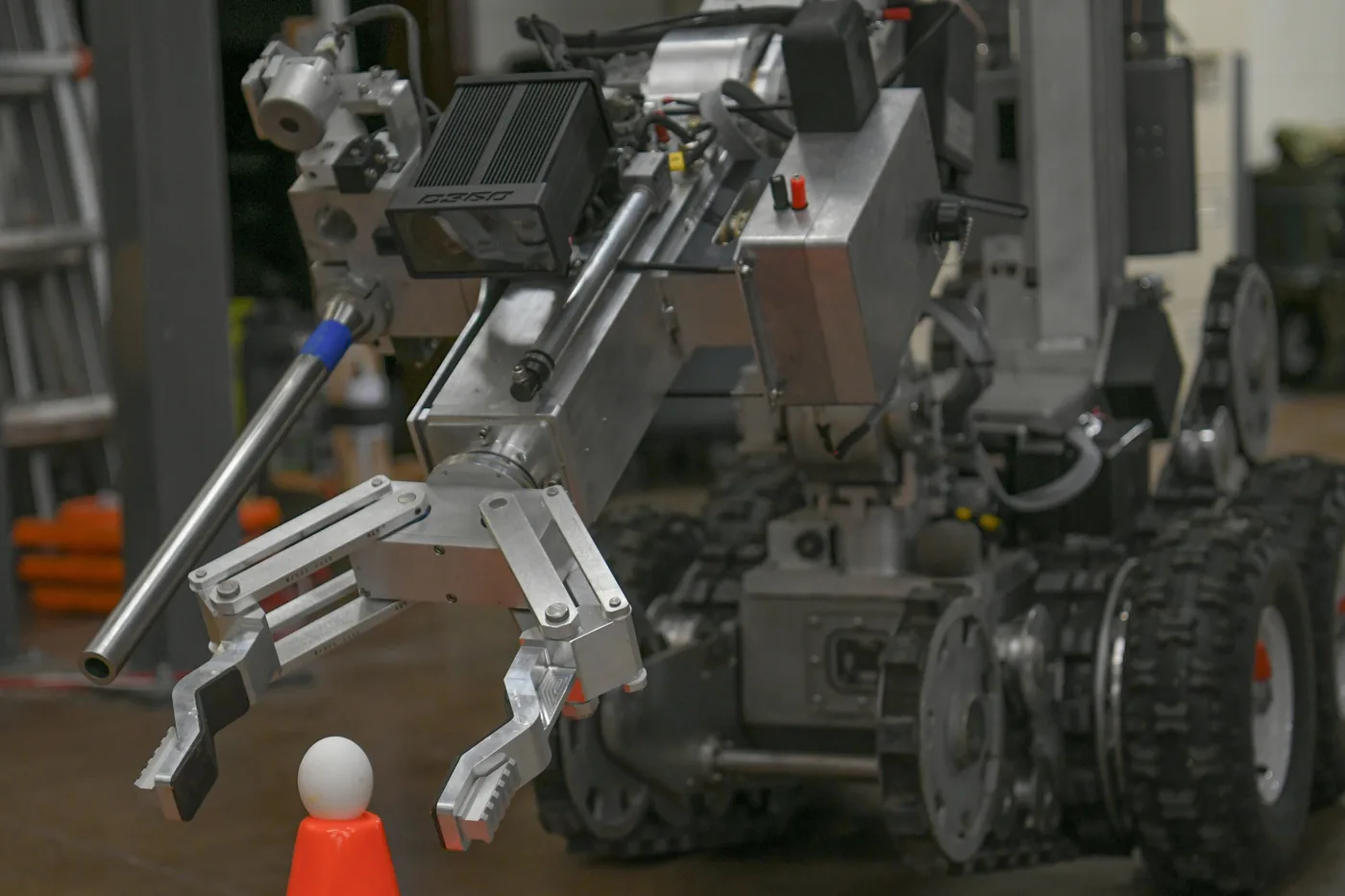 An Air Force F6 explosive-ordnance-disposal robot positions its multi-finger manipulator around an egg during a precision-handling test.