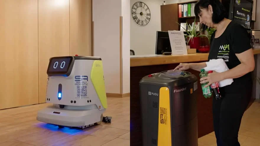 A PUDU CC1 floor-cleaning robot scrubs a Parkhotel corridor while a staff member loads supplies into a separate service robot.
