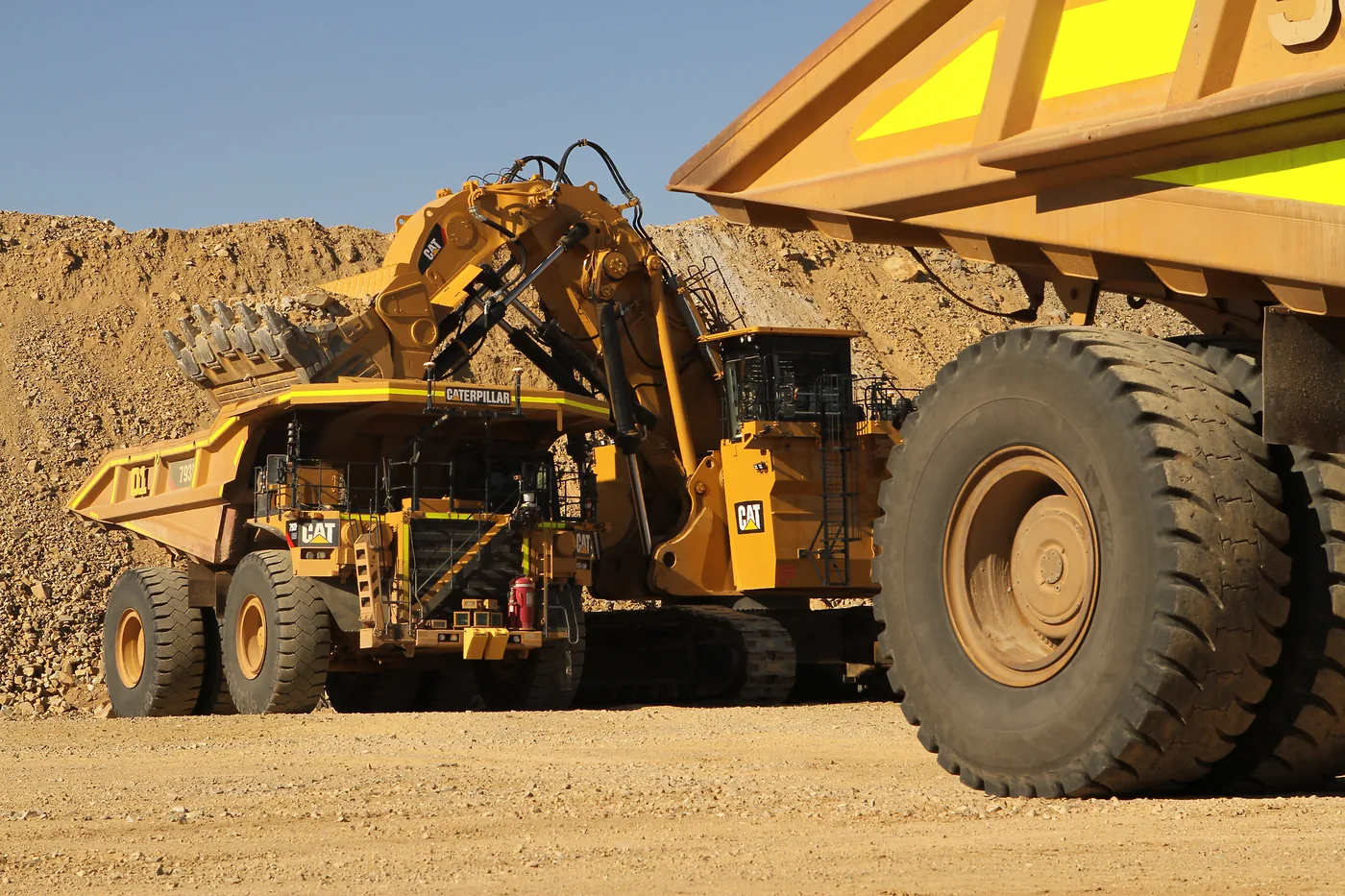 Cat 793F autonomous haul trucks line up at a loading face in the Gudai-Darri mine.