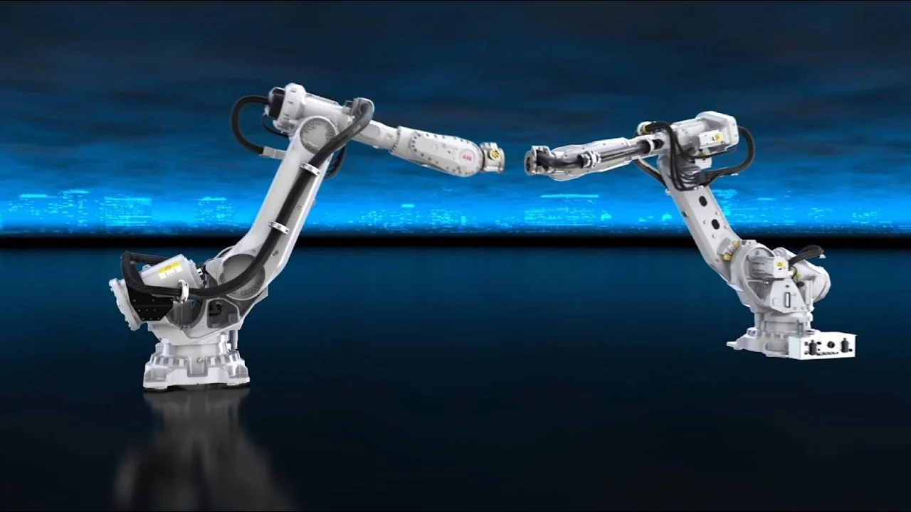 Two white ABB IRB 6700 industrial robot arms posed against a dark blue studio background