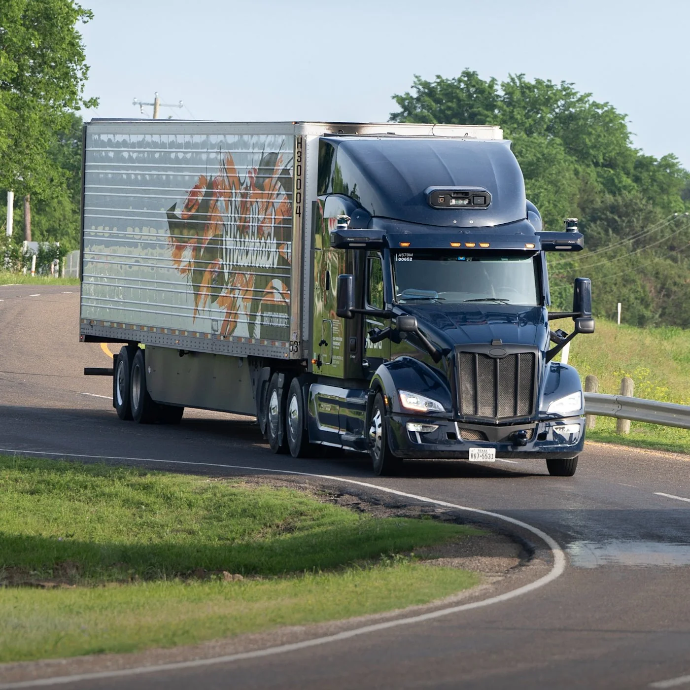 Aurora Driver-equipped autonomous Class 8 truck traveling on a divided highway