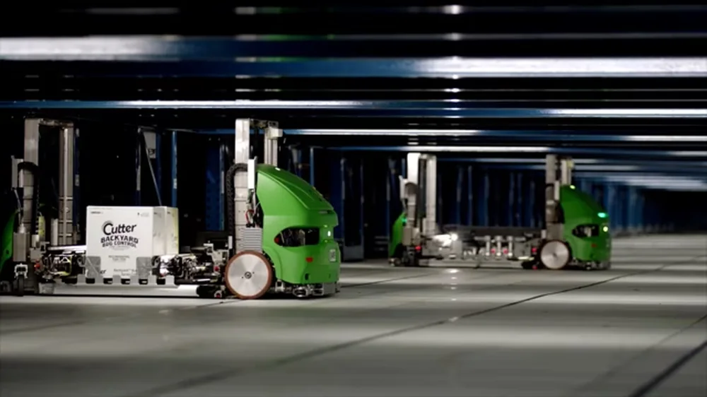 Green Symbotic autonomous mobile robots moving through the high-density structure of an automated warehouse