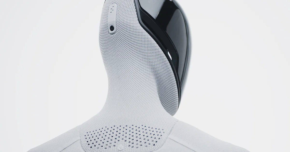 Close-up rear three-quarter view of Figure 03 showing its white knitted body covering, black shoulder shell and ventilation pattern
